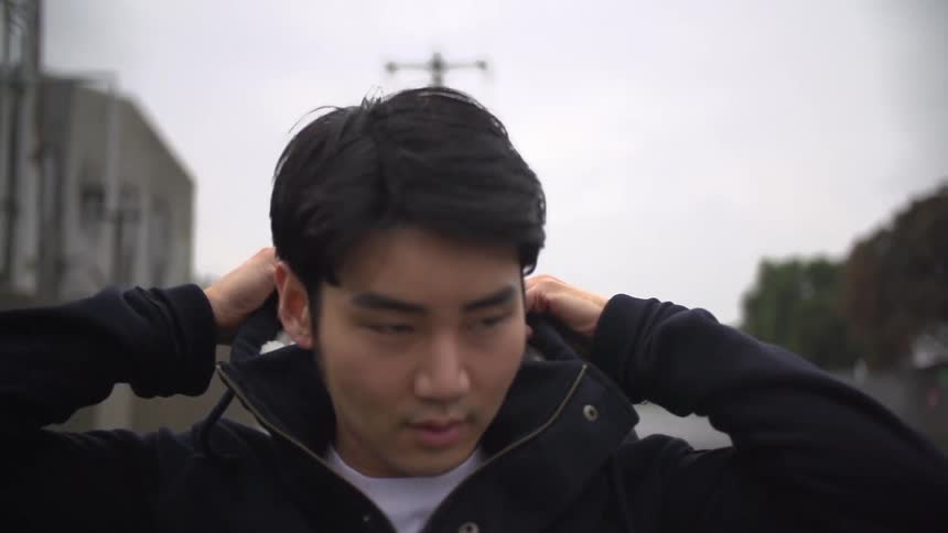 Man putting jacket hood on his head