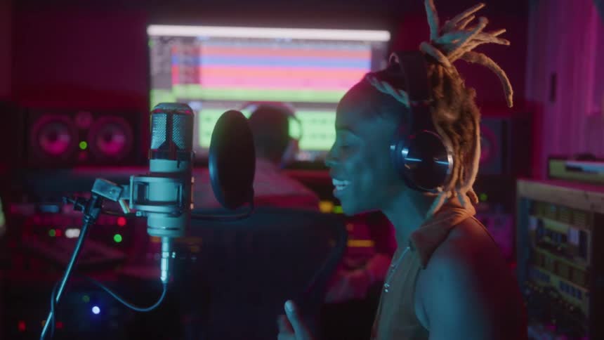 A musician records vocals passionately in a studio