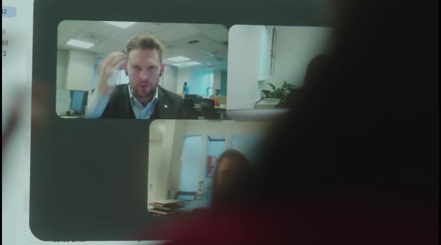 Female office worker video conferences via a computer with a large monitor