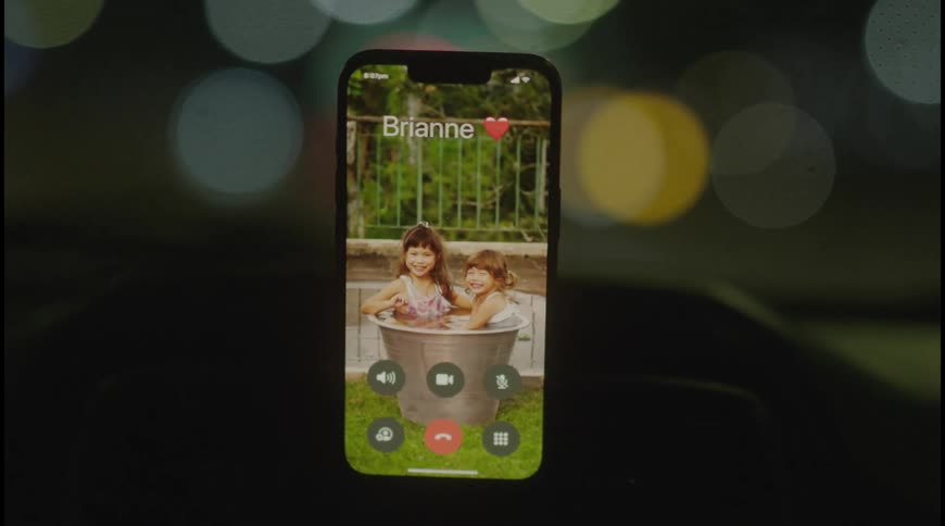 A smartphone with an active call on a car dashboard at night