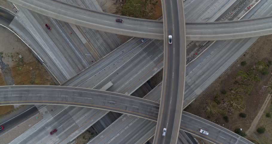 An overhead view of a multilevel highway interchange with many cars moving in different directions