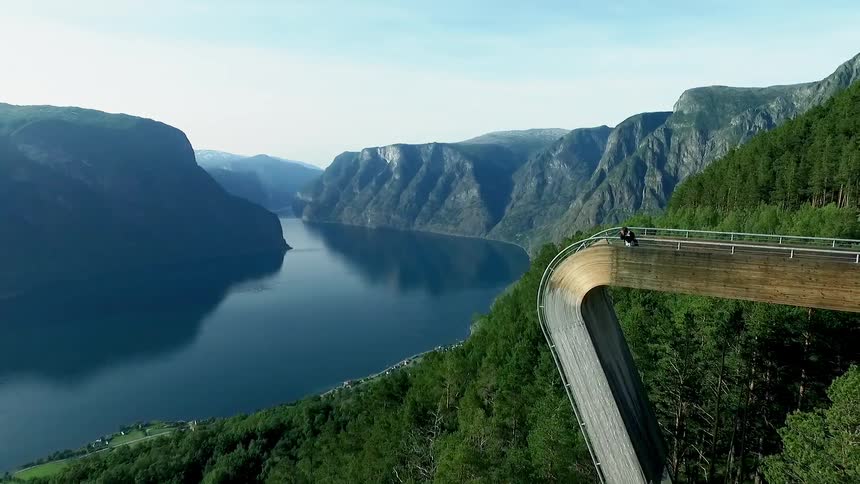 People stand on the edge of a bridge overlooking a valley