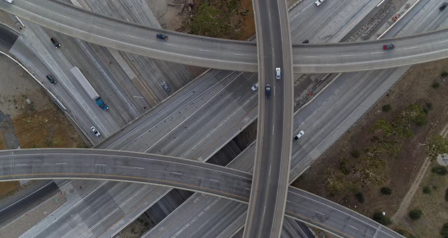 Aerial view of intersecting freeway overpasses with cars driving below