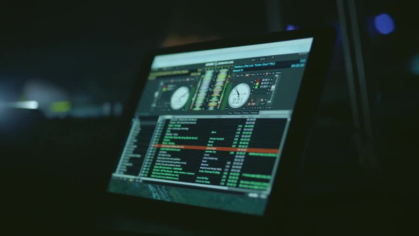 A dj plays in a club as lights strobe