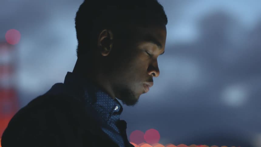 A man stands outside browsing on his phone