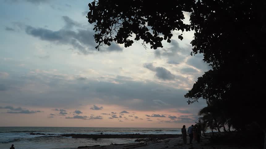 Some people on the beach in the late afternoon