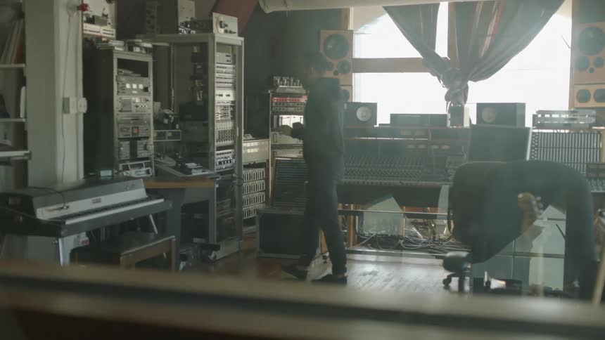 A man paces as he is working in a music studio