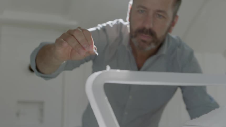 A man places paper into a steel rod
