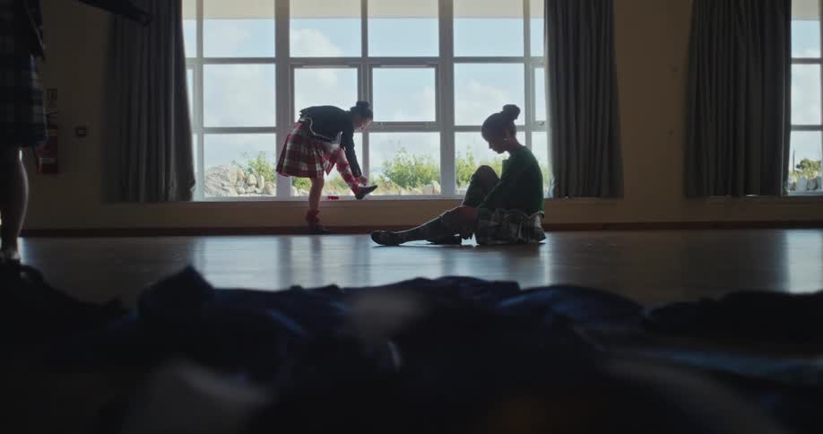 Dancers adjust their shoes in a ballroom