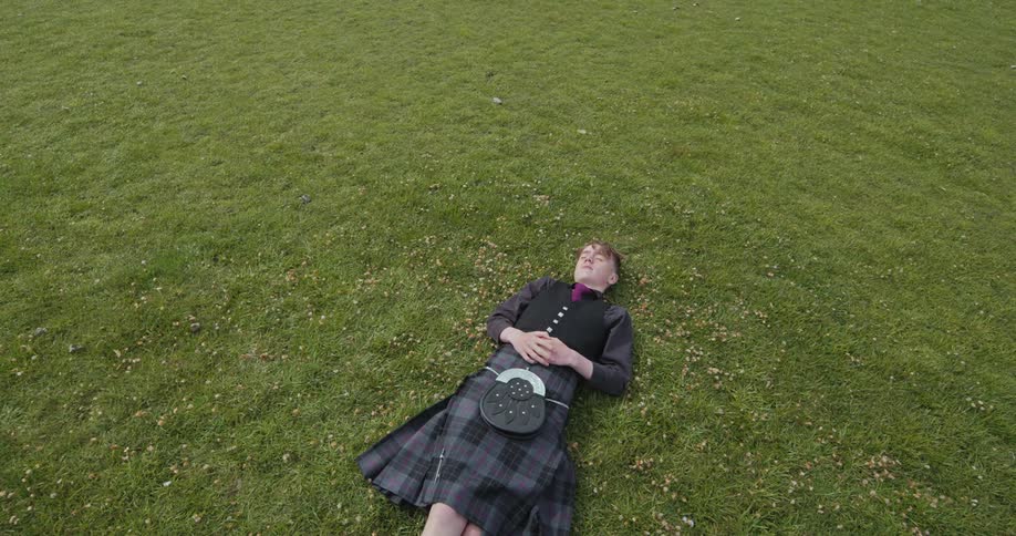 Young man lying in a field of grass