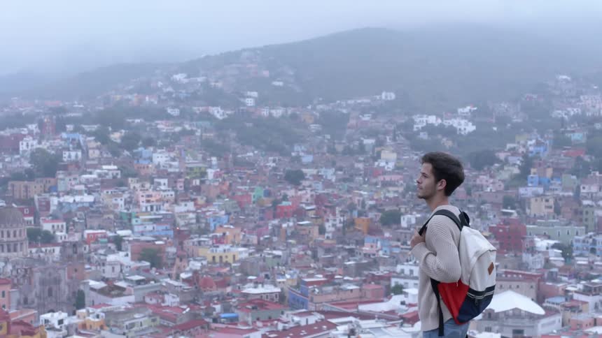 A man looks out over a town below