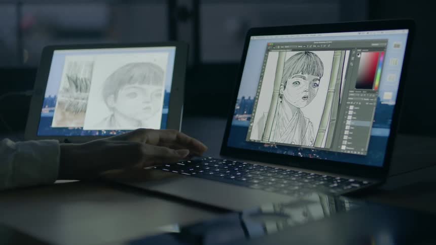 A person adjusts a drawing on a laptop