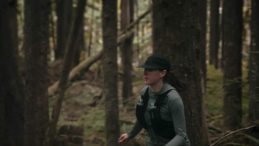 The woman is running fast through the forest