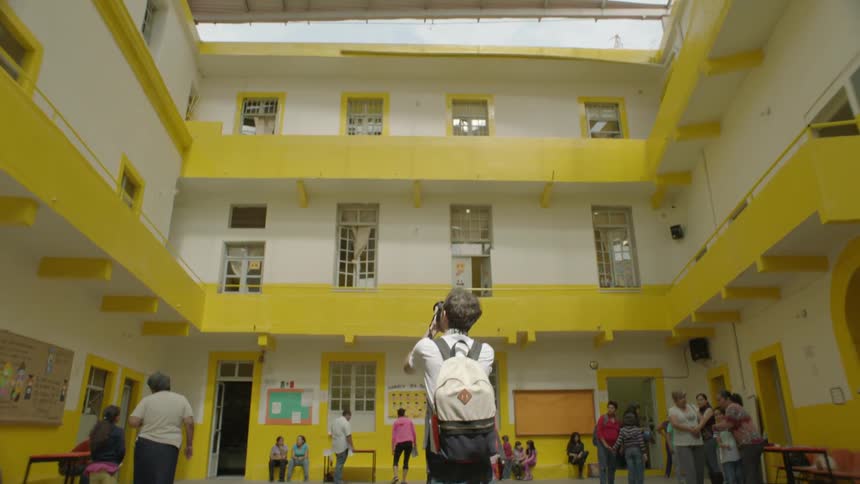People stand around a square in the middle of a building