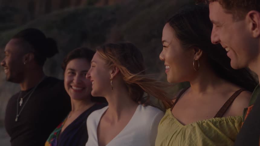 Group of friends smiling together outdoors during sunset