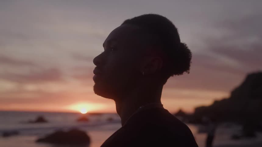 The man watches the sunrise on the sandy beach