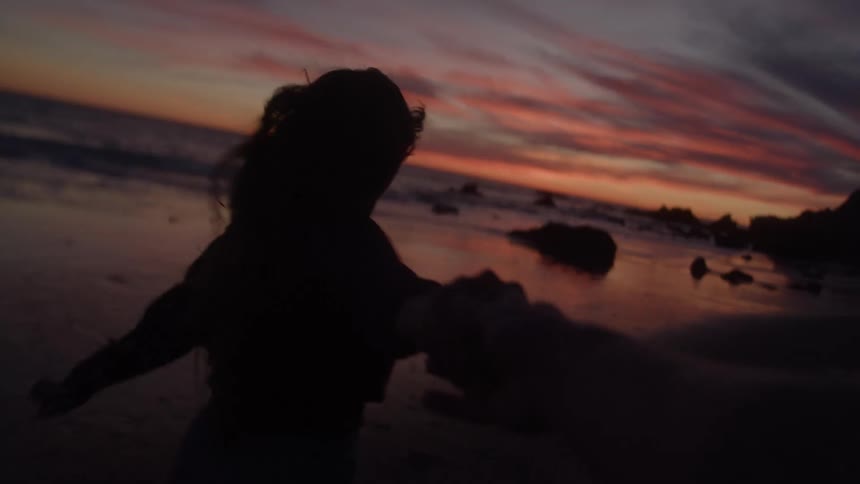 Woman running along the beach at sundown