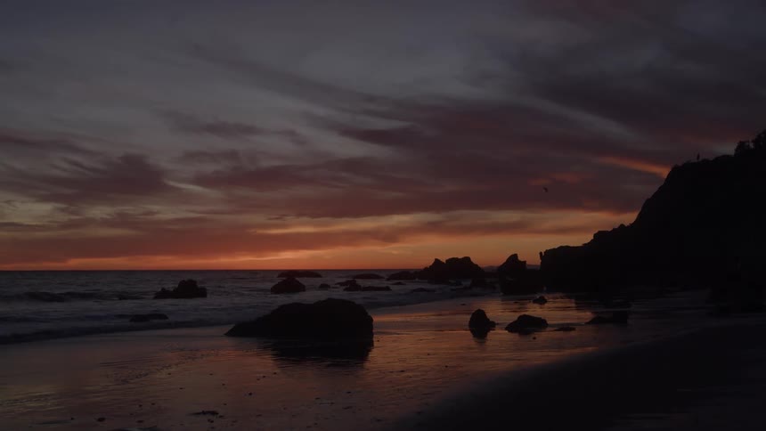 Landscape of a beach with a reddish sky on a dark dawn