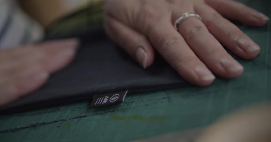 Woman smooths out the seam of a sewing project