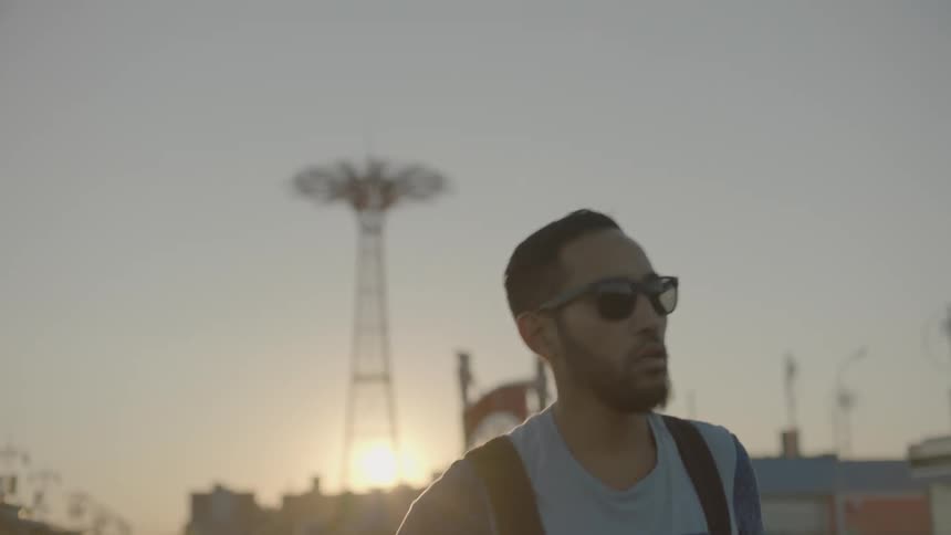 Man walking in a city away from the sunset