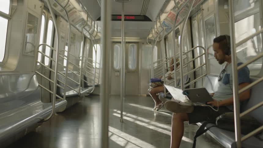 A man is reading a book riding a train