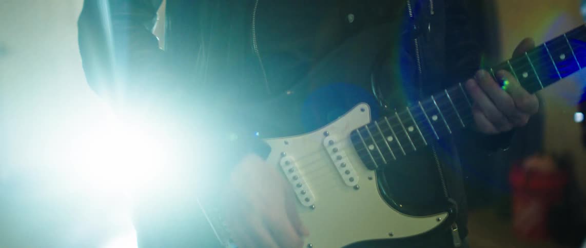 Person playing guitar in an indoor space
