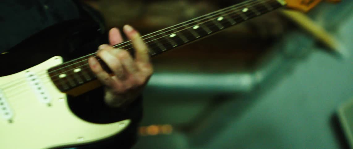 Pair of hands of a person playing guitar