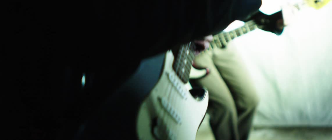 The band are strumming guitars together