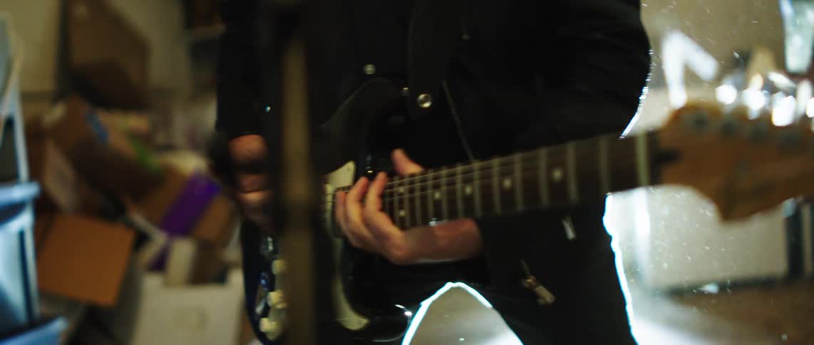 Musicians intensely playing an electric guitar during a live performance