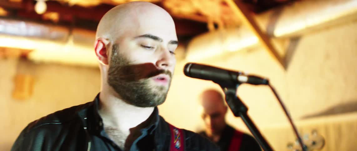 Musician singing into a microphone during a concert