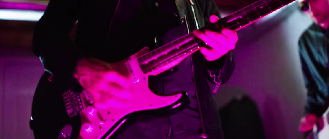 Two people in a performance playing guitar