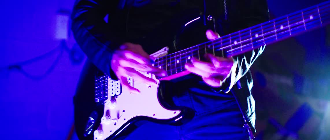 Person performing playing guitar in an indoor space