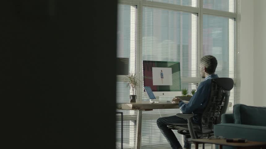 A man works at a computer in an apartment