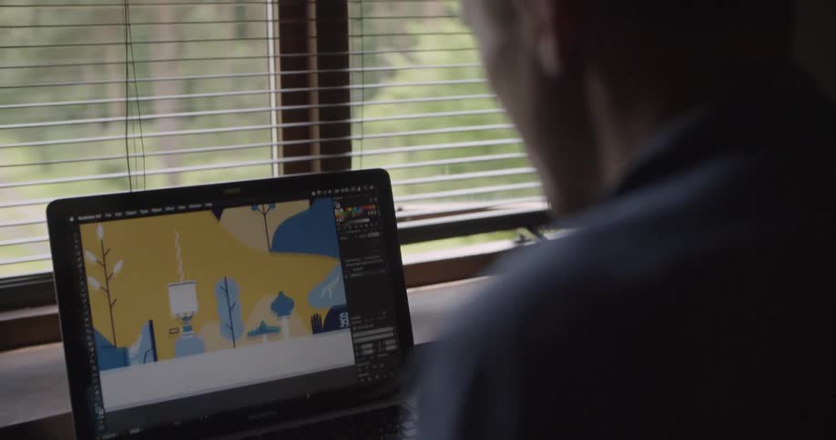 The man is viewing an image on the laptop