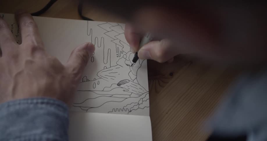Sketch artist drawing with a pen on a white paper sketchbook