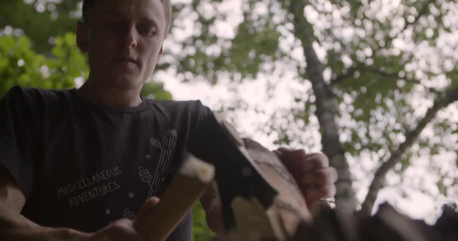 The man is chopping a piece of wood
