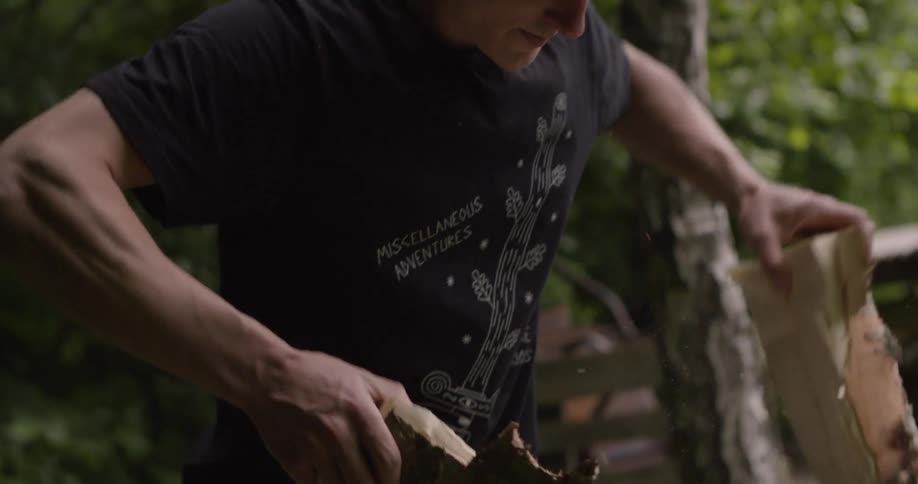 The man tears the log in half after it is cut