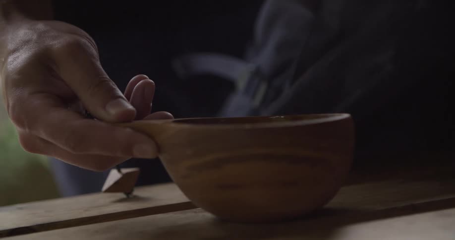 The man puts down the steaming bowl