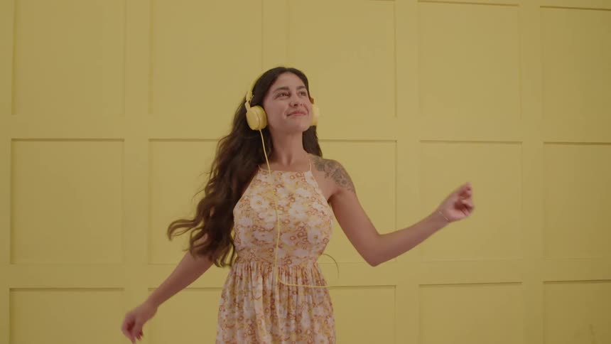 The woman is dancing while wearing headphones