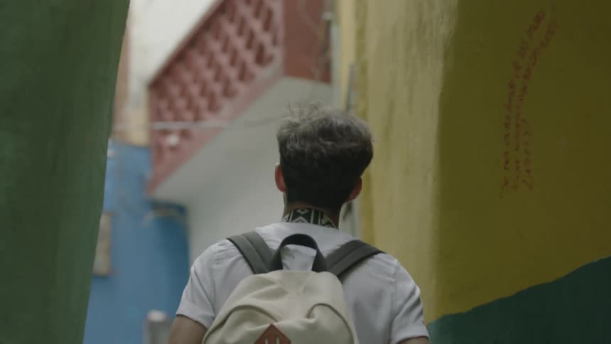 A man walks through a narrow alley