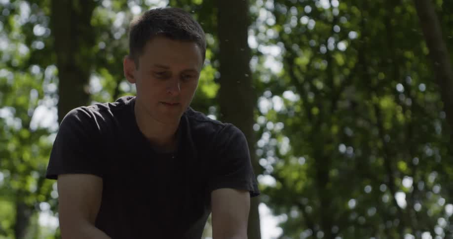 A man chops wood with an ax in a wooded area