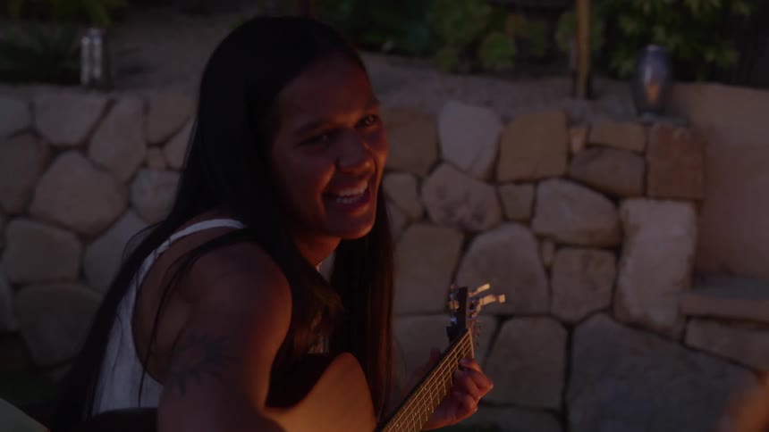A female musician is performing infront on bonfire
