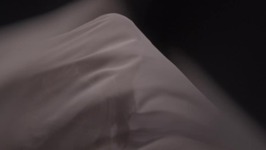 Wind blows the sheet over the woman