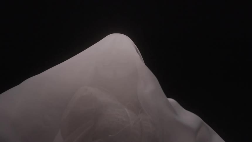 The white sheet blows over the woman