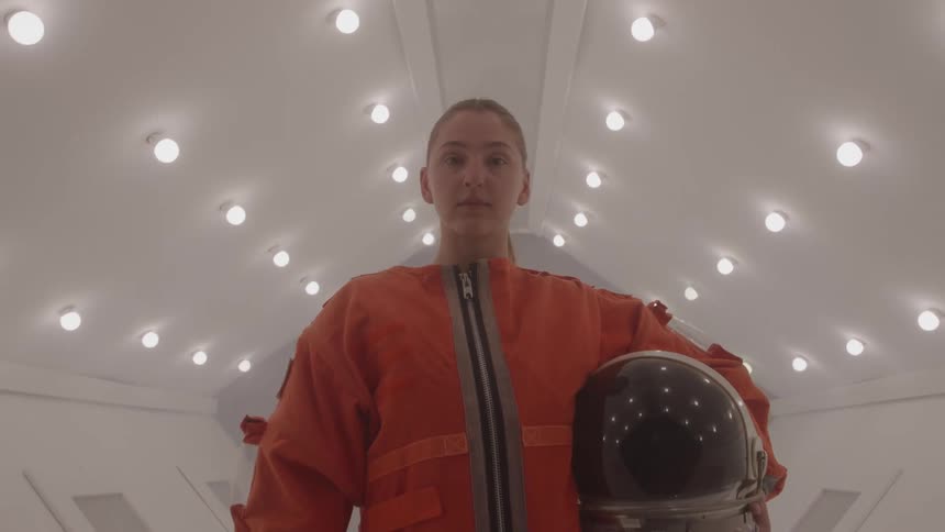 The astronaut is holding her helmet
