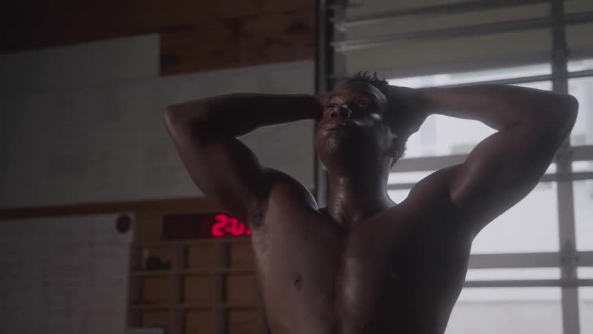 The man is breathing heavily and sweating in the gym