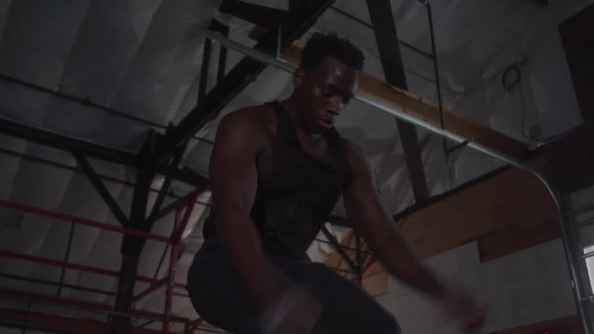 Young man doing an intensive workout in the gym at midday
