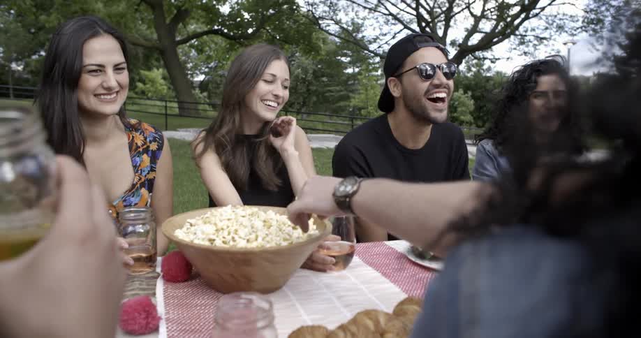 A group of people sitting at a table outside laughing