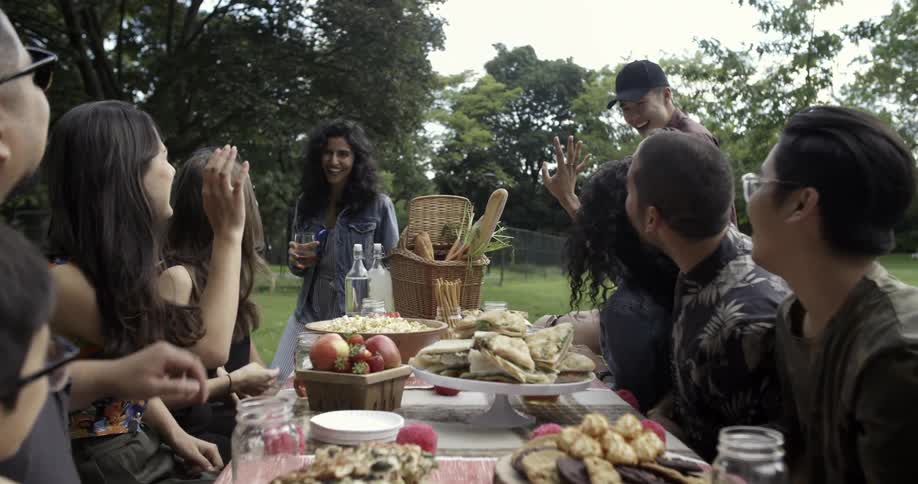 A large group of people are sitting at a table to a picnic