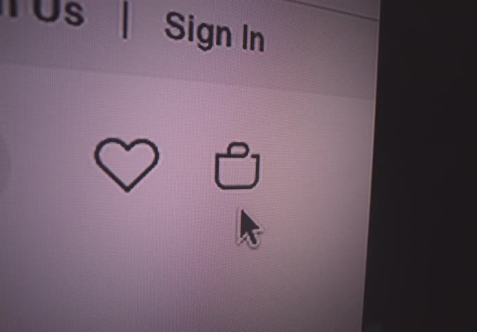 Arrow cursor scrolling through a shopping website clicking the favorite button